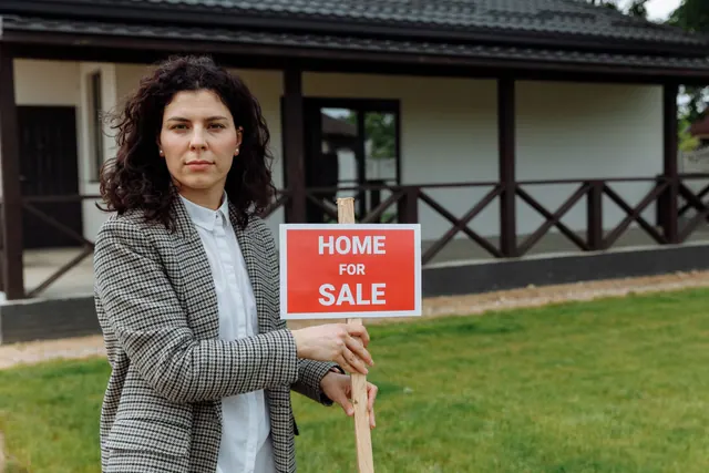 Confident real estate agent with sale sign in front of a house. Property Listing Marketing Guide for Teams